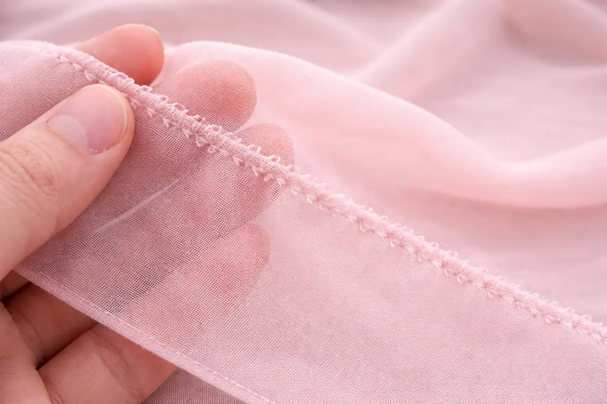 Tissu fin marqué par une couture irrégulière à cause d’un réglage trop fort ou d’une aiguille trop grosse